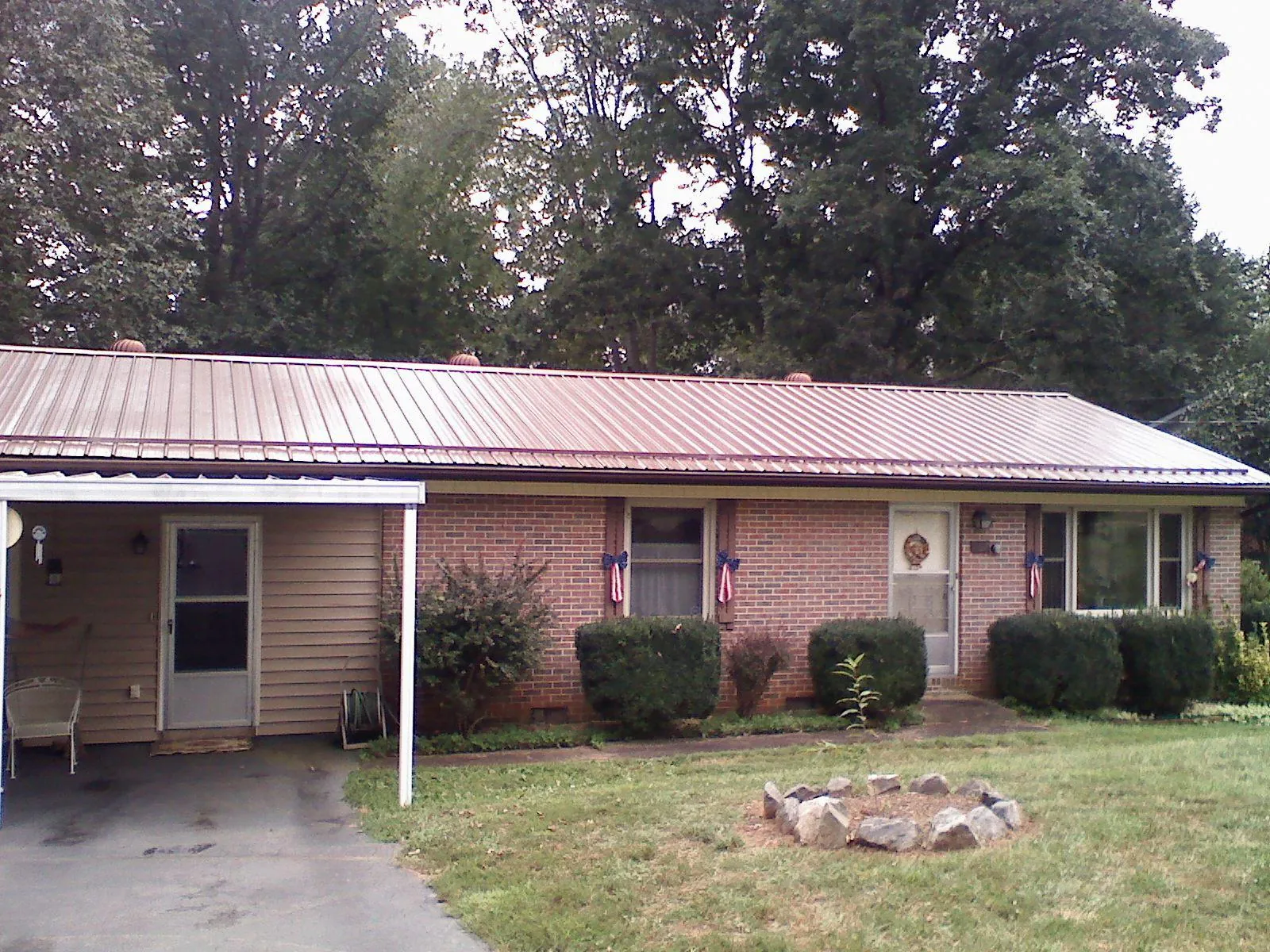 Bronze metal roof and carport on a brick ranch home — Roof Repair work by our crew in Ashville